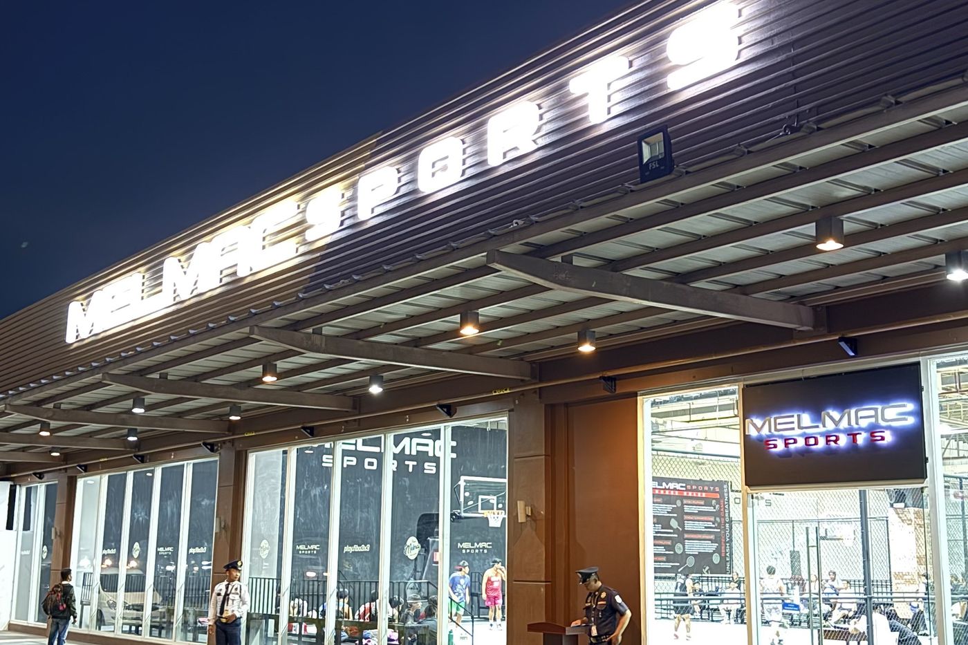 The lit Melmac Sports building at Vista Mall Imus at night