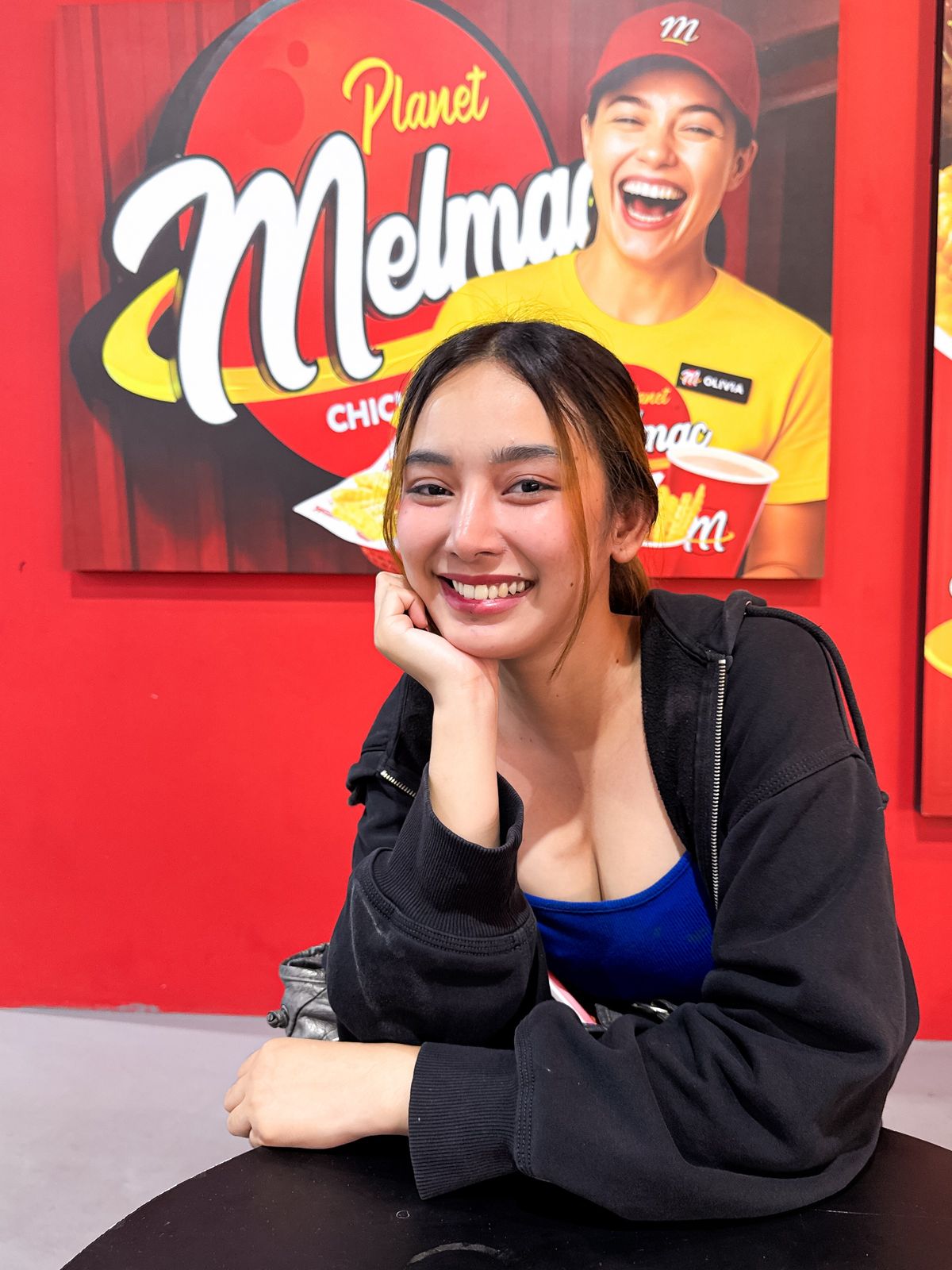 A customer at a table beneath the Planet Melmac Chick ’n Chips sign at Imus