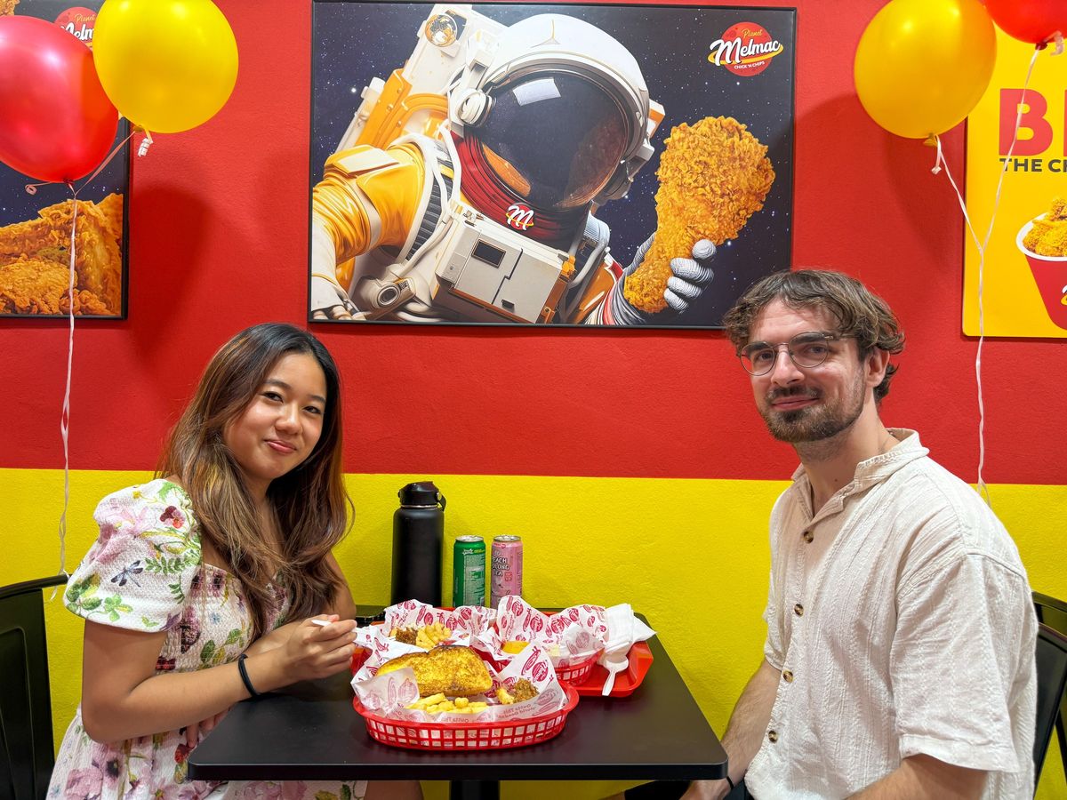 Two customers with baskets of chicken and chips at Planet Melmac Singapore