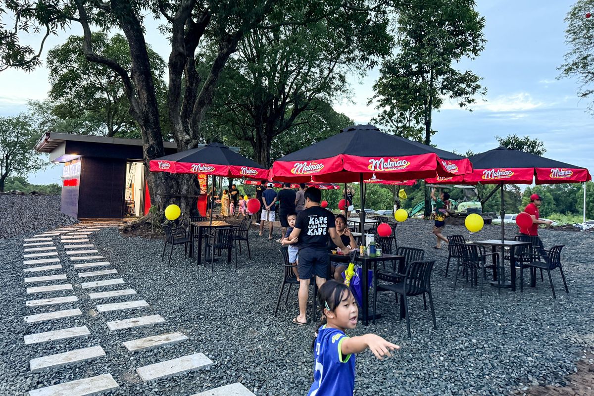 Planet Melmac’s outdoor tables and umbrellas under the trees at Villar City