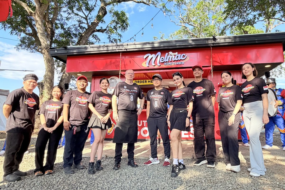 The Planet Melmac team lined up in front of the kiosk at Villar City