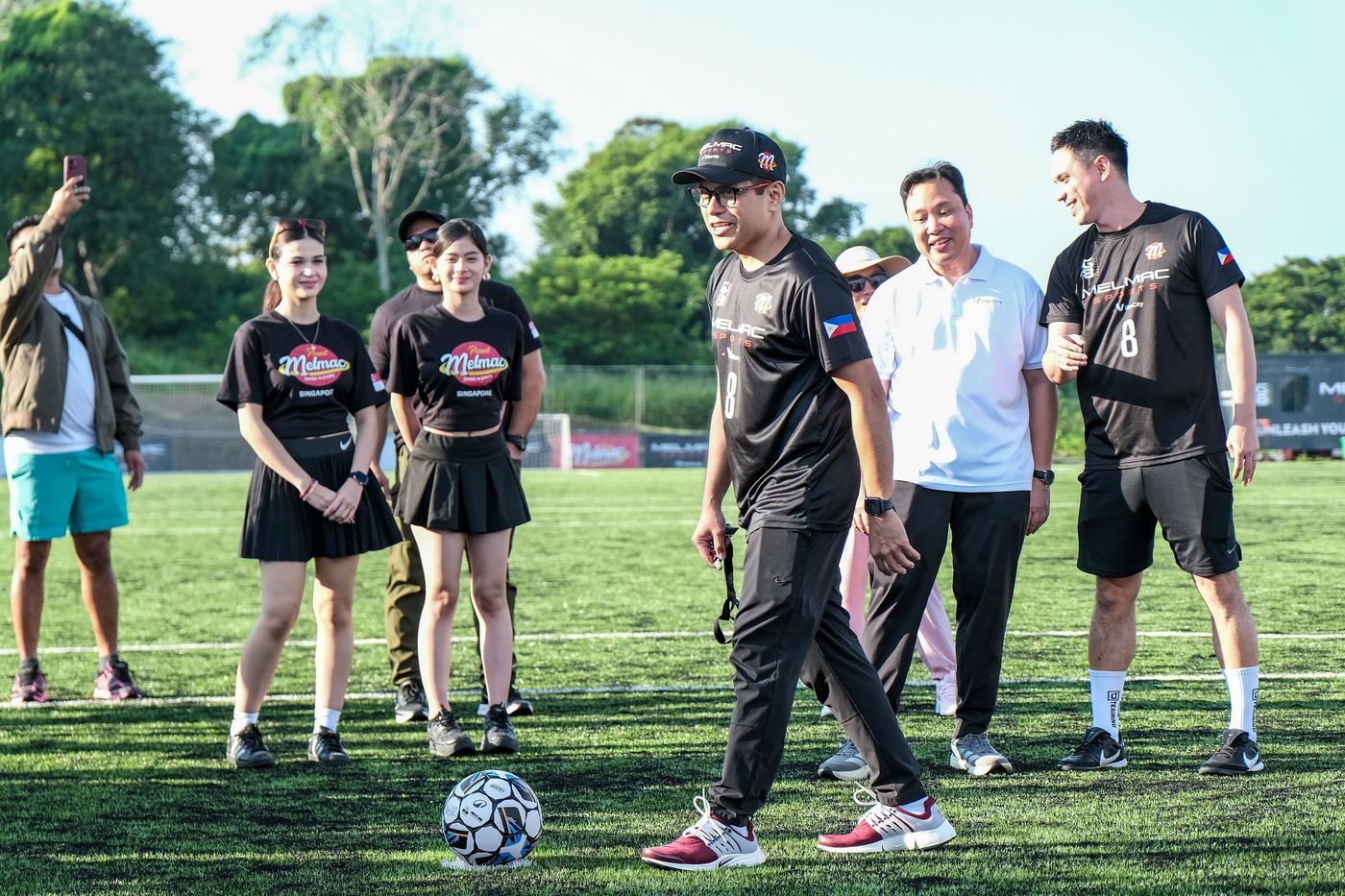 Guests and players watching a ceremonial kick-off on the pitch at Villar City