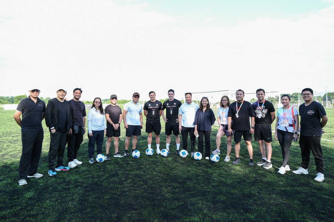 A long line of players and guests standing across the pitch at Villar City
