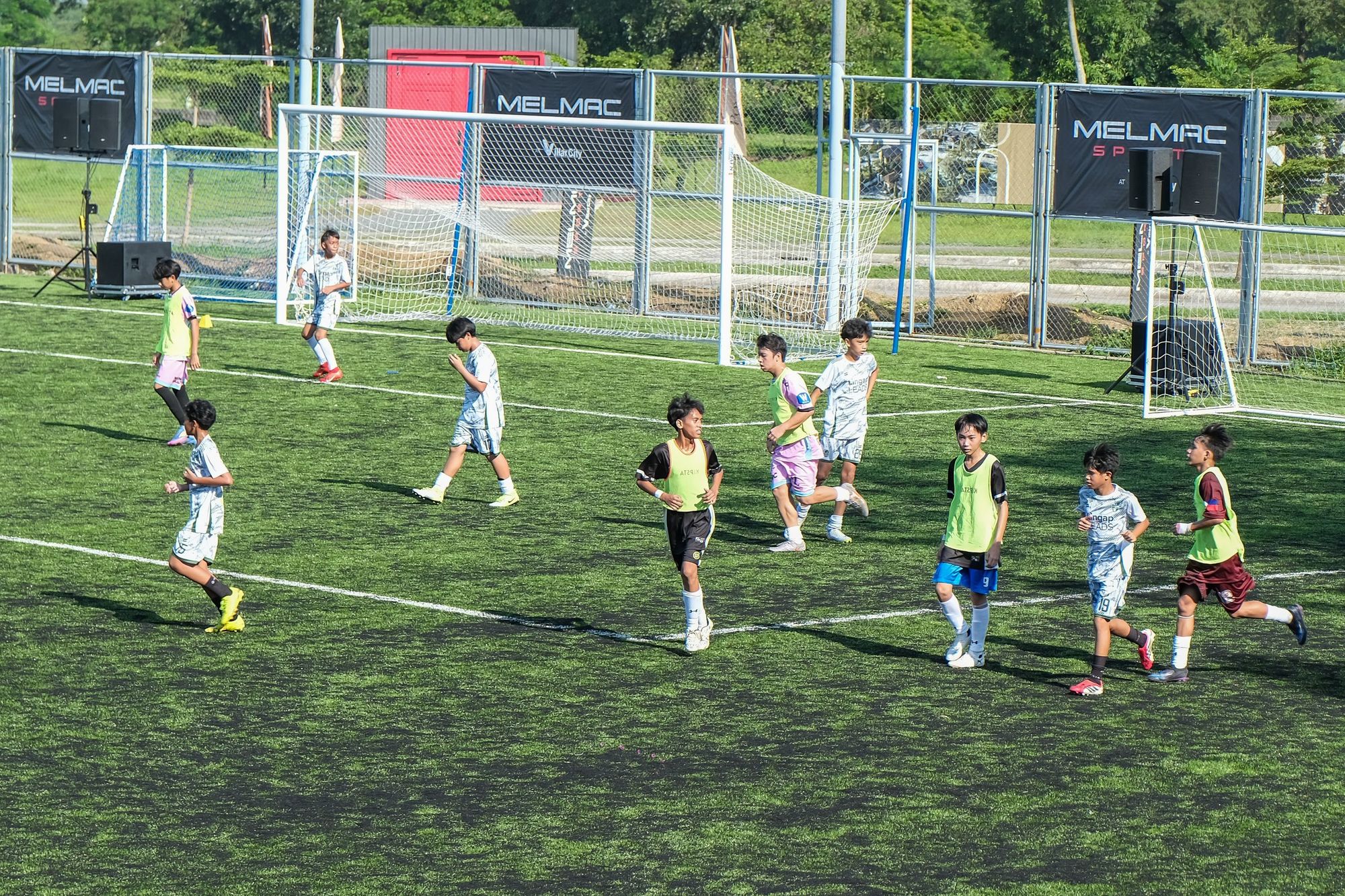 Children playing a match across the pitch at Villar City