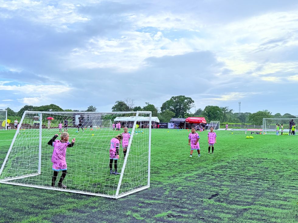 A small goalkeeper in the goal at Villar City under a wide evening sky