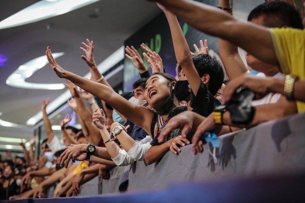 Fans reaching over the barrier with hands raised at a 3x3 event
